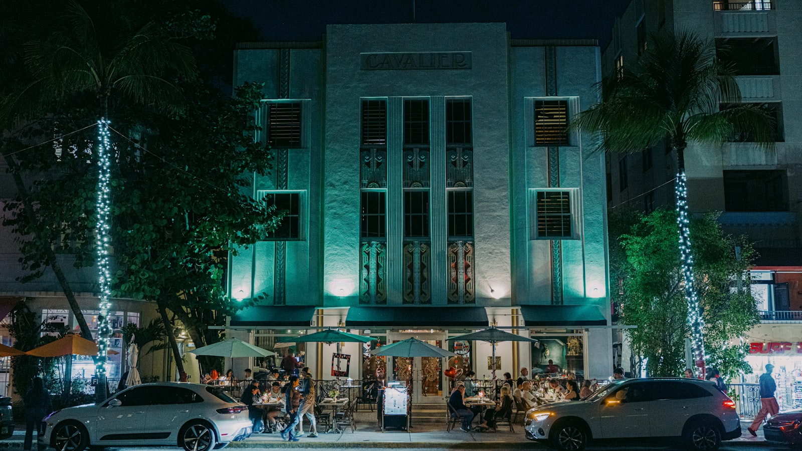 Art-deco boutique hotel facade at dusk with outdoor diners